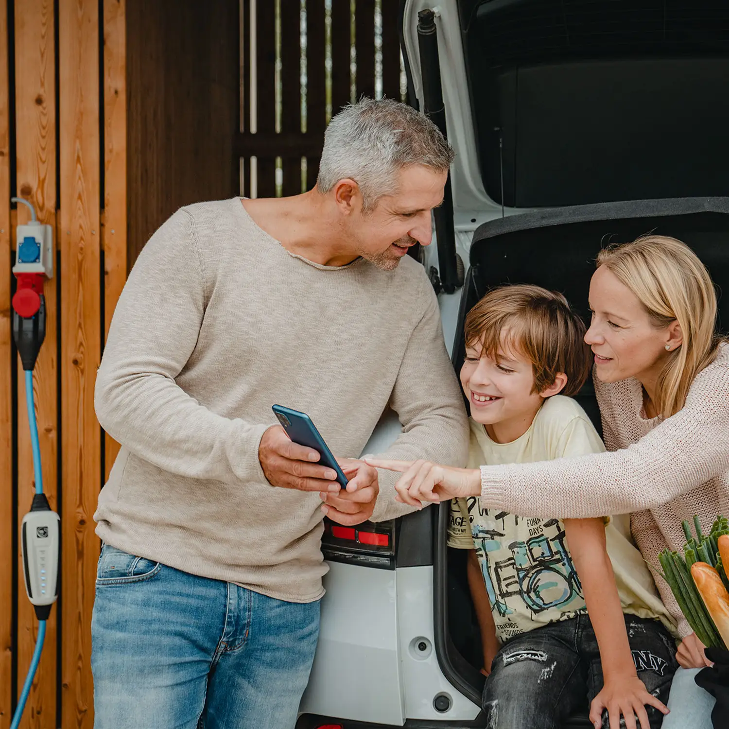 Familie lädt Elektroauto mit mobiler Wallbox-NRGkick.