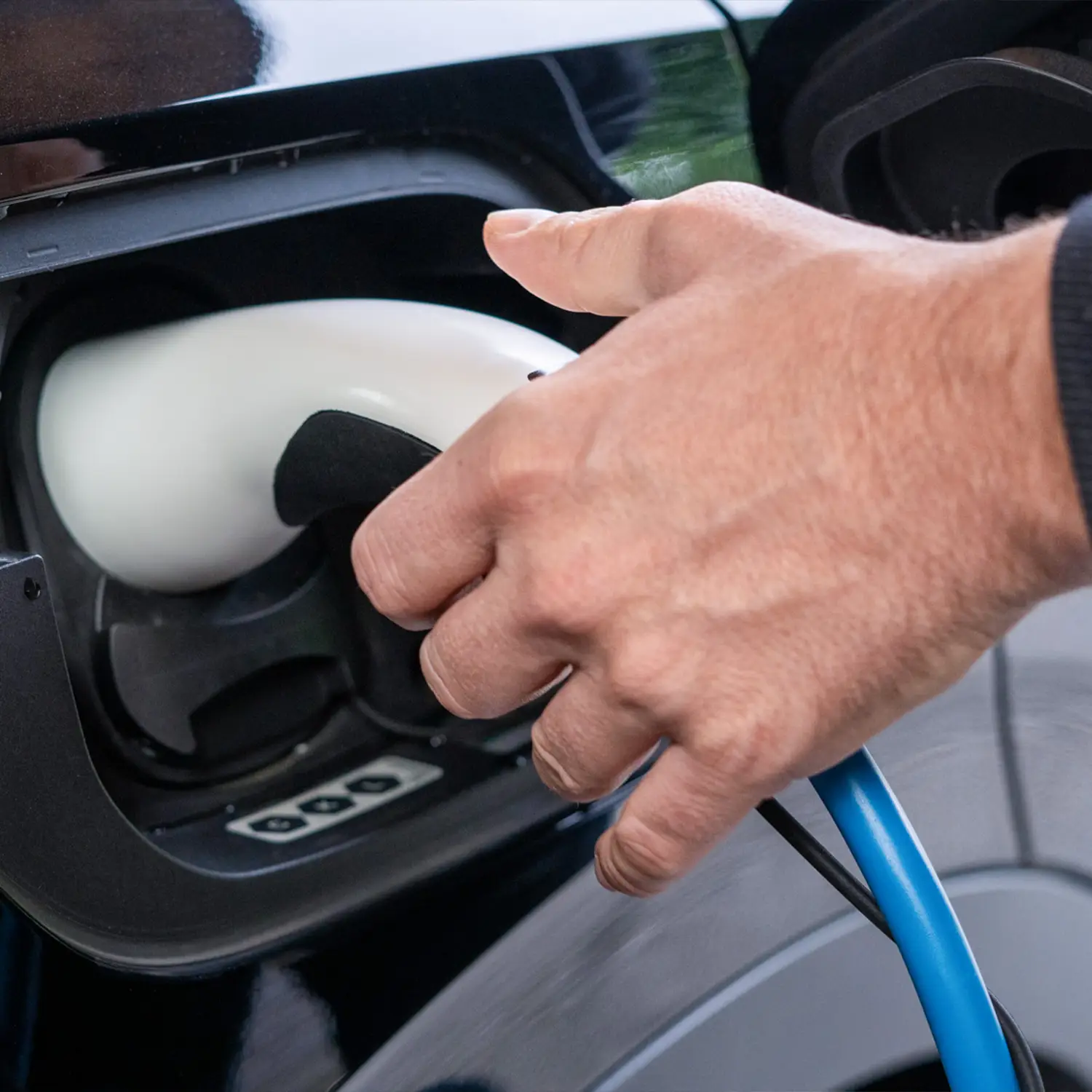 Mann verbindet Elektroauto mit NRGkick-Ladestation zum Laden.