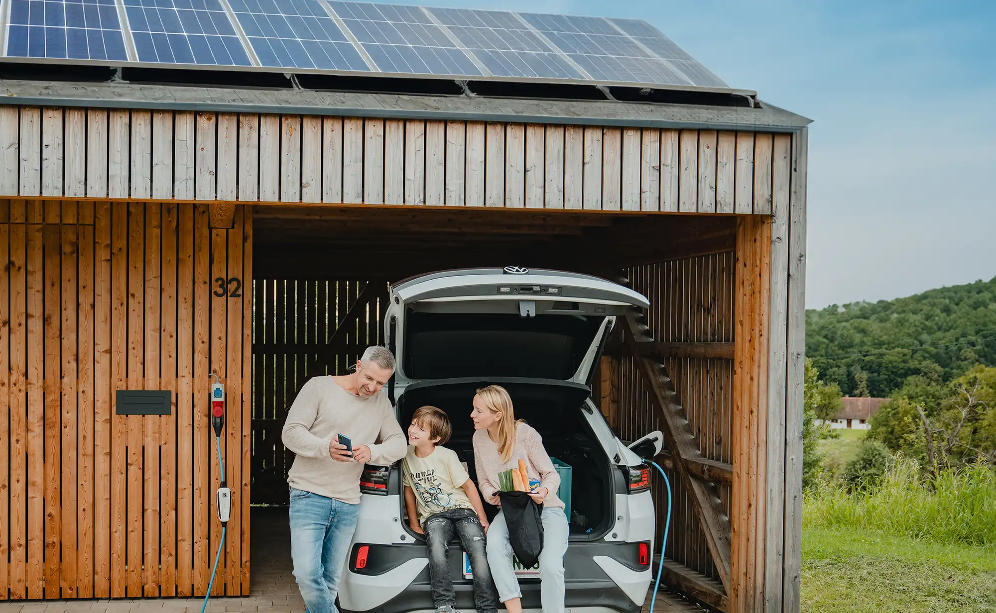 Familie lädt zuhause mit der PV-Anlage das E-Auto.