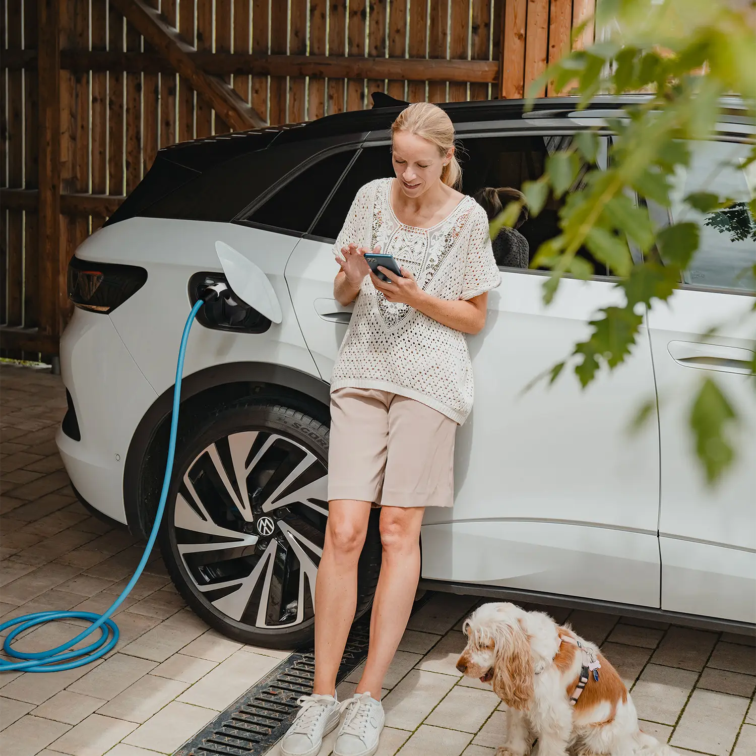 Frau nutzt Smartphone, um NRGkick Tutorials anzusehen.